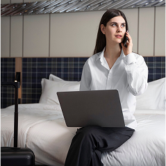 Woman working on laptop in modern hotel space
